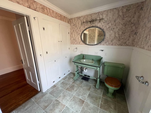 bathroom featuring sink, crown molding, and toilet