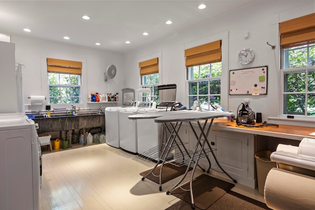 interior space with gray cabinetry, plenty of natural light, light wood-type flooring, and a kitchen bar