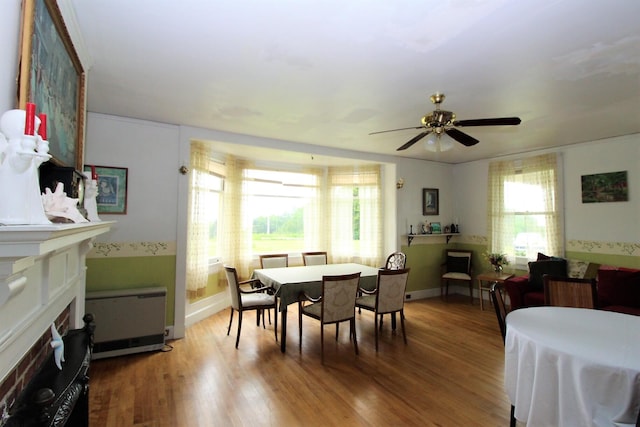 dining area featuring radiator heating unit, ceiling fan, and hardwood / wood-style flooring