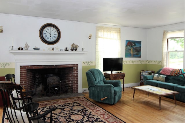 living room with hardwood / wood-style floors and a brick fireplace