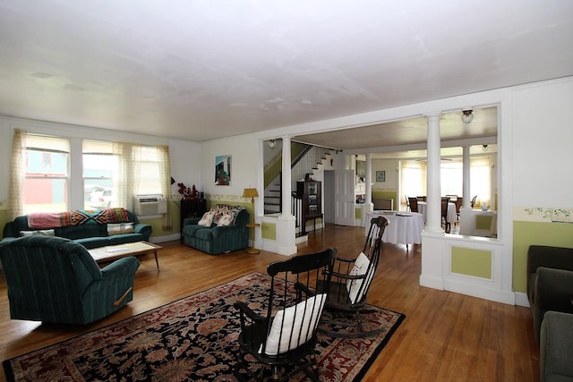 living room featuring wood-type flooring and ornate columns