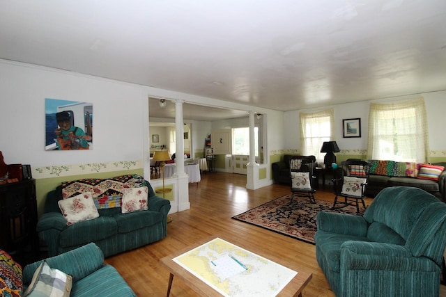 living room featuring light hardwood / wood-style flooring and decorative columns