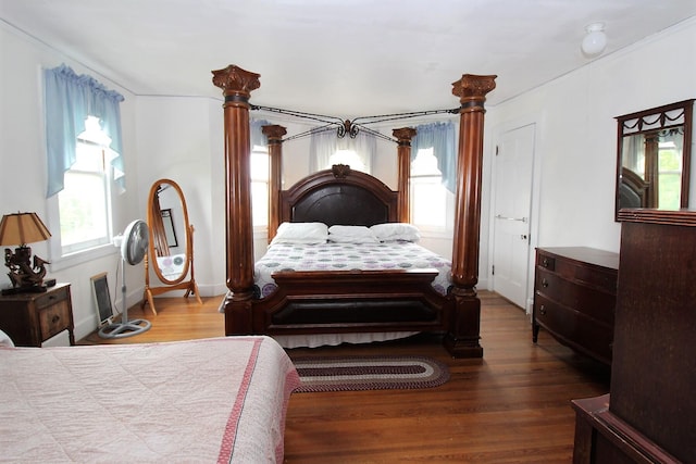 bedroom with hardwood / wood-style flooring and multiple windows