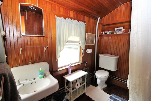 bathroom with lofted ceiling, toilet, wooden walls, and wood-type flooring