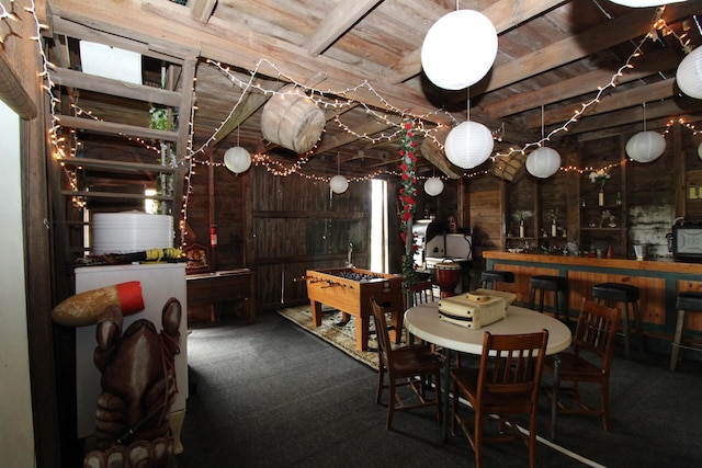 carpeted dining room featuring indoor bar and wood ceiling