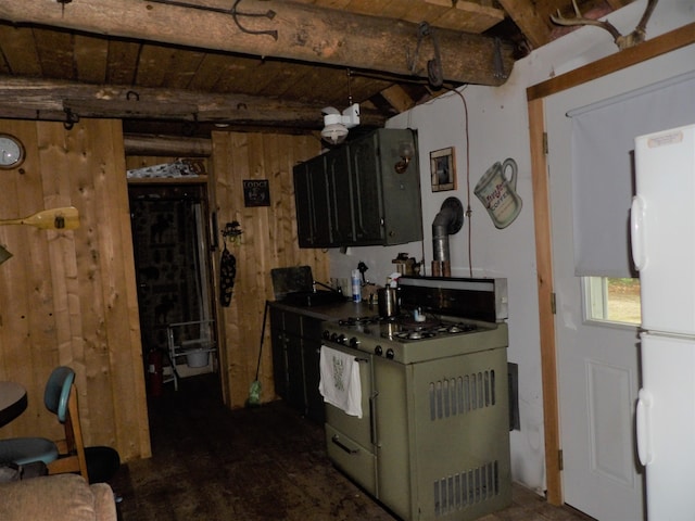 kitchen featuring white fridge, wood walls, and range with gas stovetop