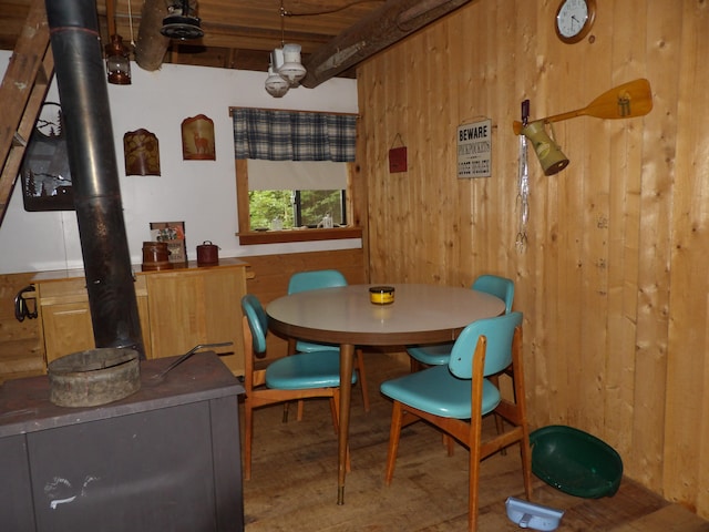 dining space with wood-type flooring and wooden walls