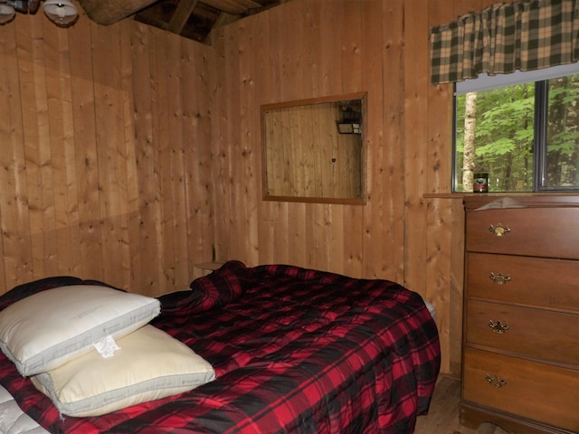 bedroom featuring wood walls