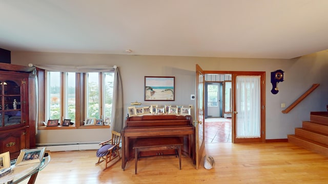 bedroom featuring french doors, a baseboard radiator, and light hardwood / wood-style flooring