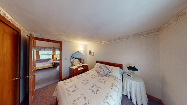 carpeted bedroom featuring baseboards and wallpapered walls