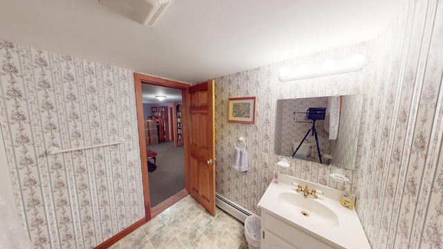 bathroom with visible vents, baseboards, vanity, baseboard heating, and wallpapered walls