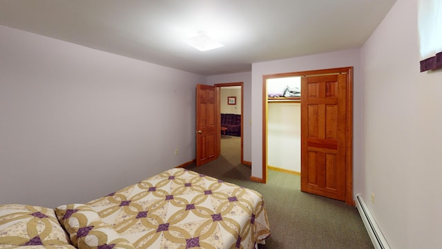 carpeted bedroom featuring a baseboard radiator, a walk in closet, and baseboards