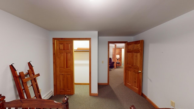 carpeted bedroom with a baseboard radiator and baseboards