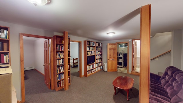 living area with a baseboard heating unit and carpet flooring