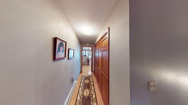 hallway with baseboard heating and wood-type flooring