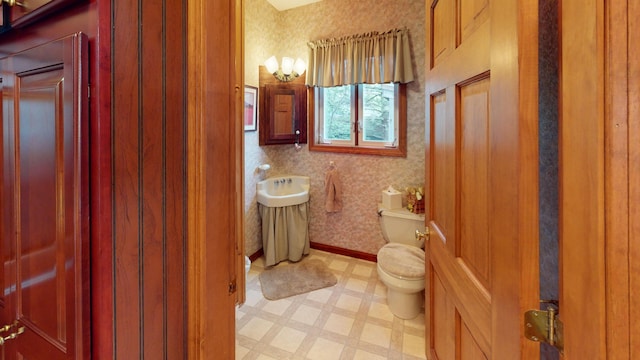 half bath with tile patterned floors, baseboards, toilet, and wallpapered walls