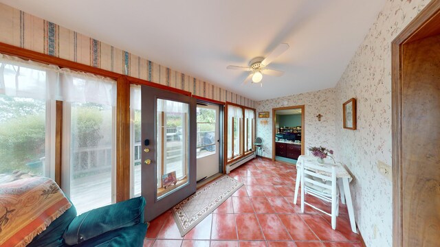 sunroom / solarium featuring baseboard heating and ceiling fan