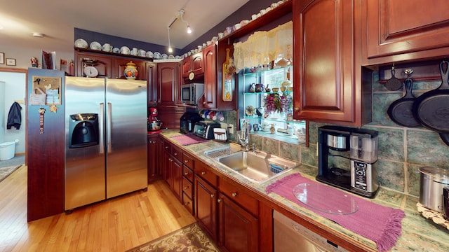 kitchen featuring light wood-type flooring, stainless steel appliances, track lighting, and sink