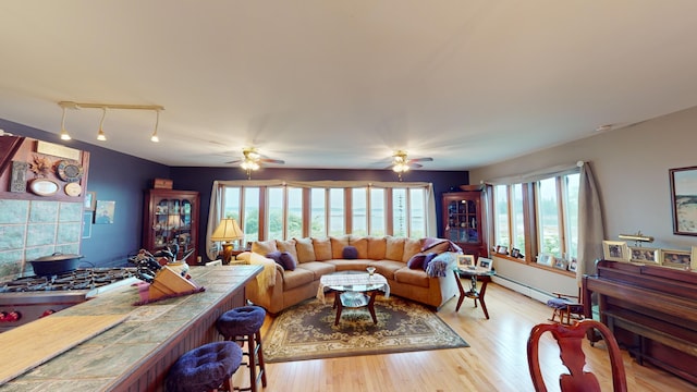 living room with a baseboard radiator, ceiling fan, and light hardwood / wood-style floors