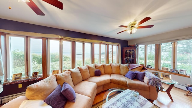 living room featuring a baseboard heating unit, ceiling fan, plenty of natural light, and wood-type flooring