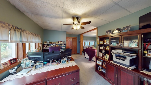 carpeted office space featuring a paneled ceiling and ceiling fan