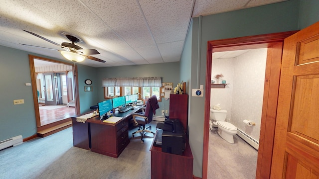 carpeted office featuring a baseboard heating unit and ceiling fan