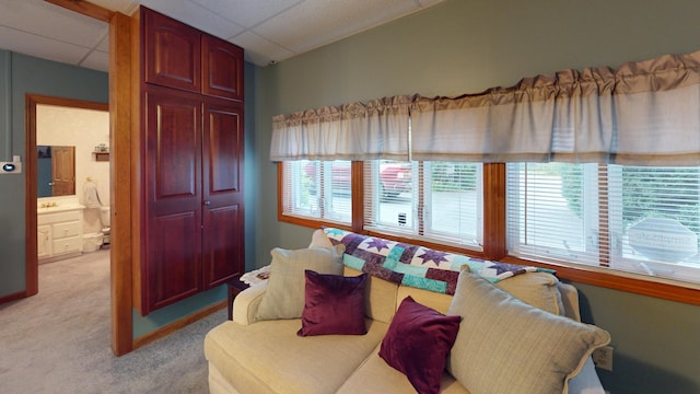 living room featuring light carpet and a drop ceiling