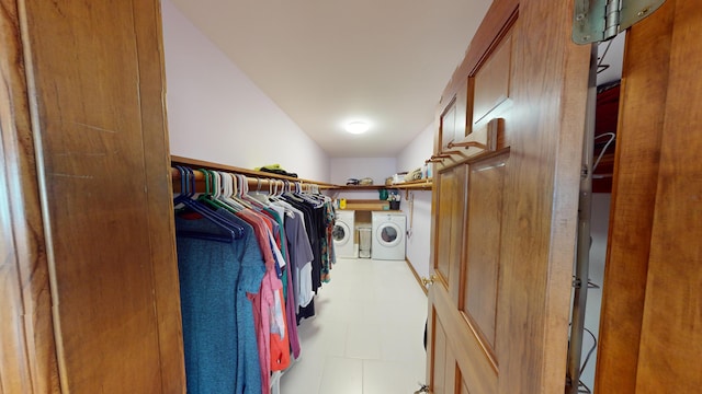 walk in closet with light floors and washing machine and dryer