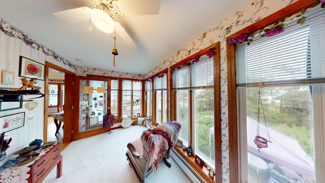 sunroom featuring a baseboard radiator and ceiling fan