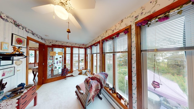 sunroom / solarium featuring a healthy amount of sunlight and ceiling fan