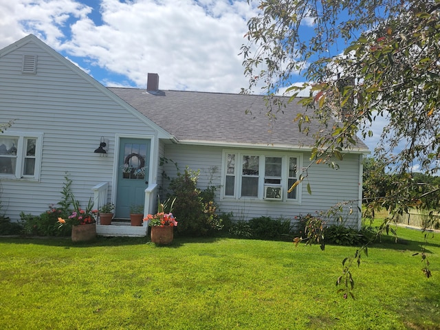 rear view of property featuring a yard