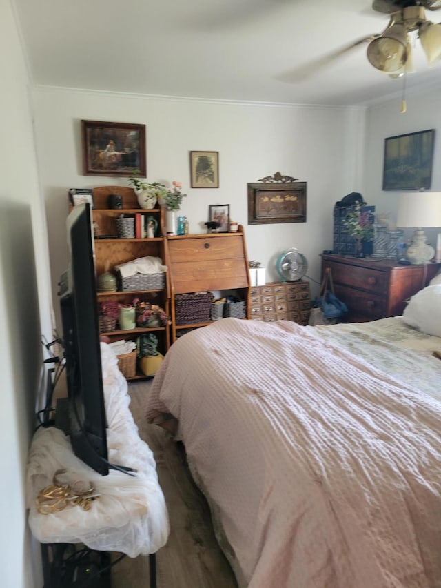 bedroom with crown molding, ceiling fan, and hardwood / wood-style flooring