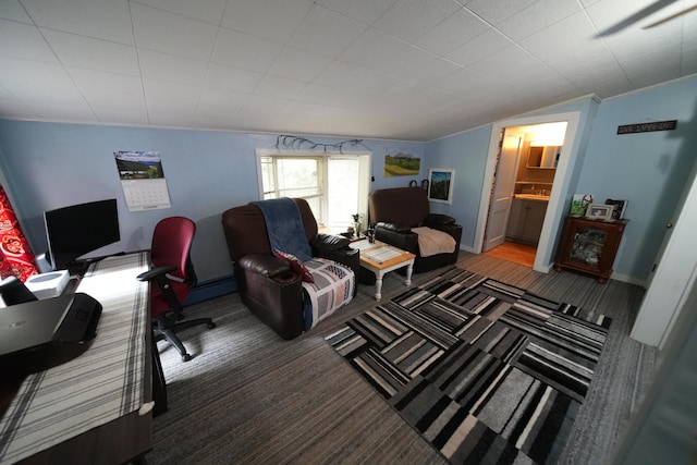 carpeted home office featuring vaulted ceiling and a baseboard heating unit