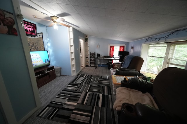 living room with ceiling fan and dark colored carpet