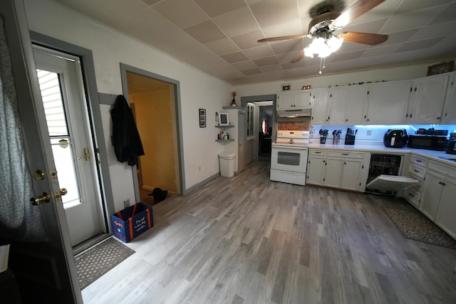 kitchen featuring white electric range, a healthy amount of sunlight, ceiling fan, and white cabinets