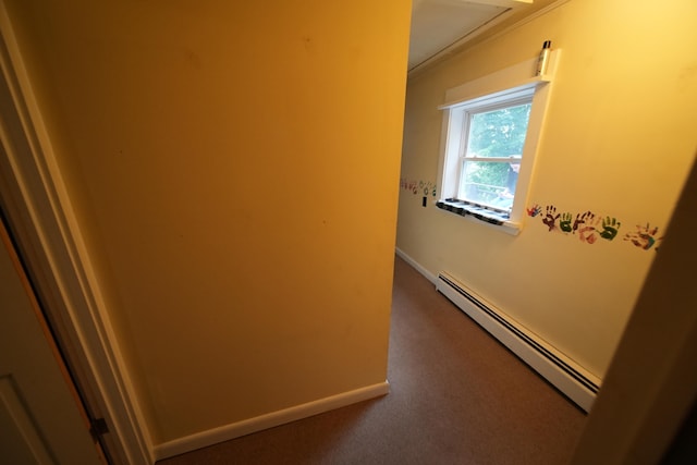 corridor featuring dark carpet and a baseboard heating unit