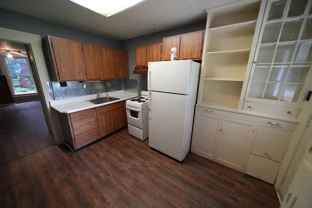 kitchen featuring tasteful backsplash, ceiling fan, white appliances, sink, and dark hardwood / wood-style floors