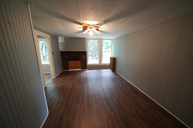 interior space with dark hardwood / wood-style flooring, ceiling fan, and a fireplace