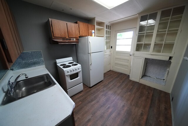 kitchen featuring white appliances, dark wood-type flooring, and sink