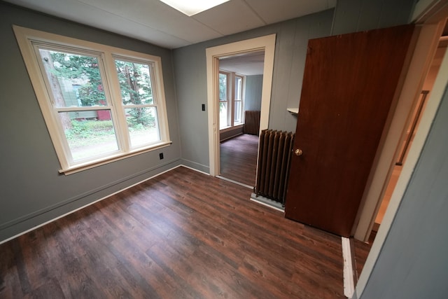 spare room with radiator and dark wood-type flooring