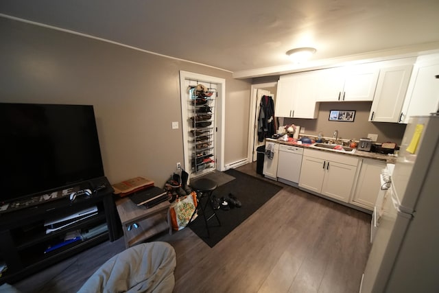 kitchen featuring white appliances, white cabinetry, dark wood-type flooring, and sink