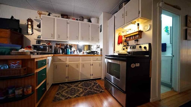 kitchen with stainless steel electric range, dark hardwood / wood-style floors, and white cabinets