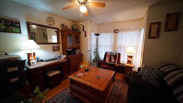 living room featuring ceiling fan and a drop ceiling