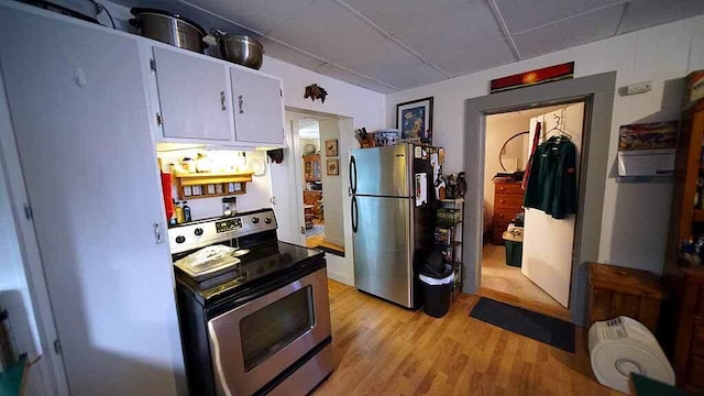 kitchen featuring stainless steel appliances, light wood-type flooring, a drop ceiling, and white cabinets