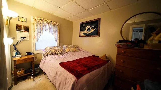 carpeted bedroom with a drop ceiling