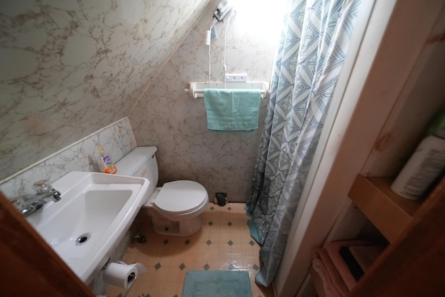 bathroom featuring lofted ceiling, toilet, tile floors, and sink