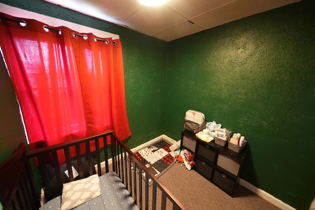 bedroom with a paneled ceiling and carpet