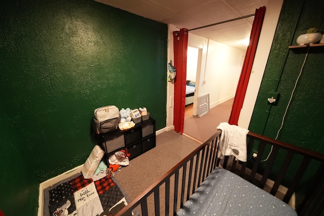 interior space featuring carpet flooring and a drop ceiling