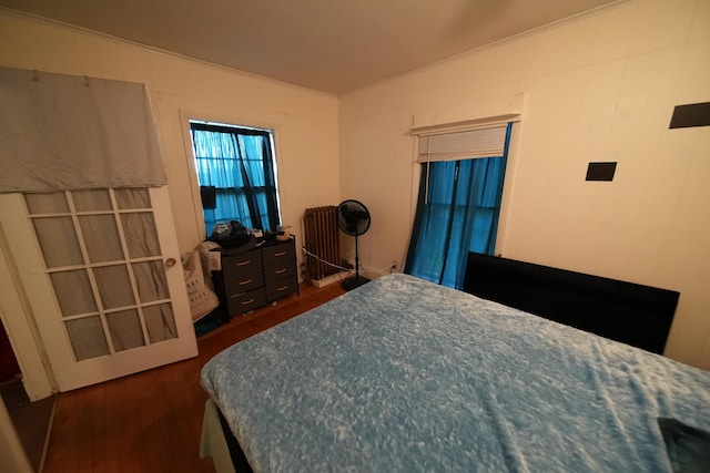 bedroom featuring dark hardwood / wood-style flooring and radiator