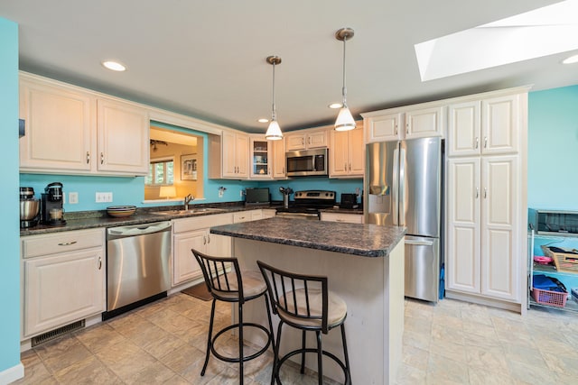 76 Heritage Dr Unit 5, Wells, ME 04090 - kitchen featuring stainless steel appliances, a sink, a skylight, a breakfast bar area, and a kitchen island